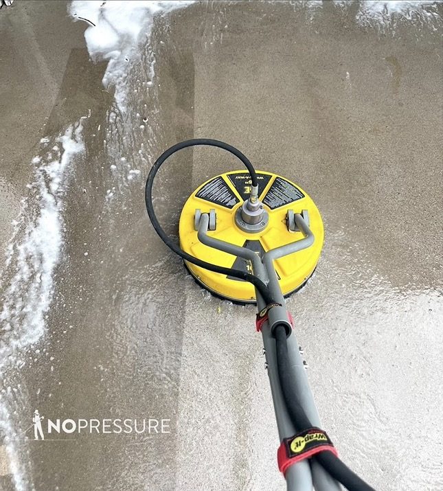 No Pressure technician running a rotary surface cleaner across concrete